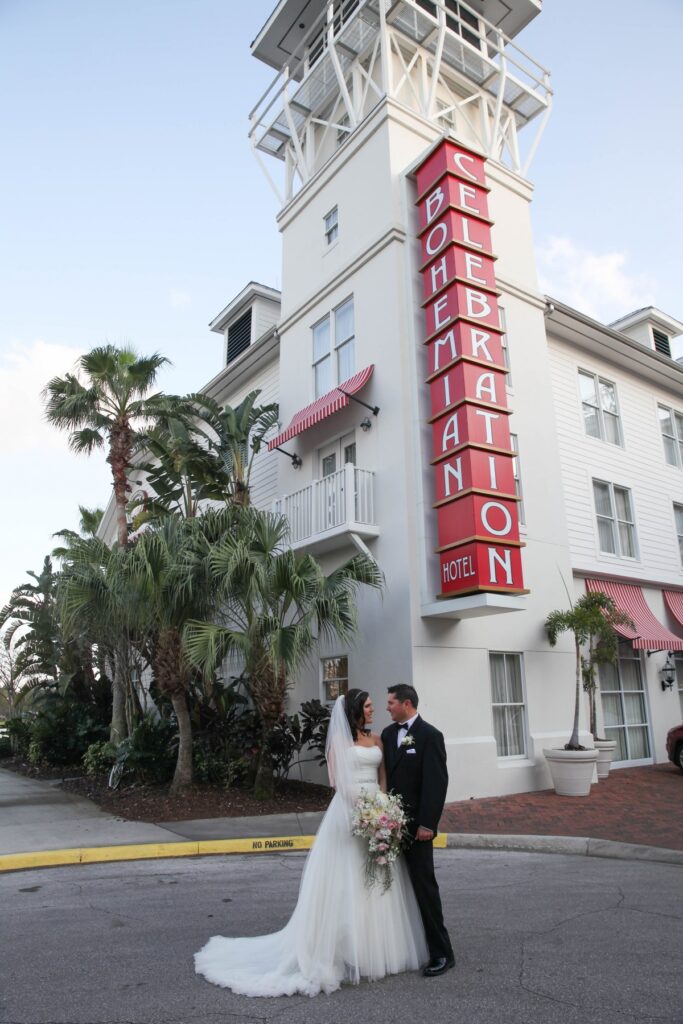 bride and groom just married standing outside bohemian hotel celebration on sunny day